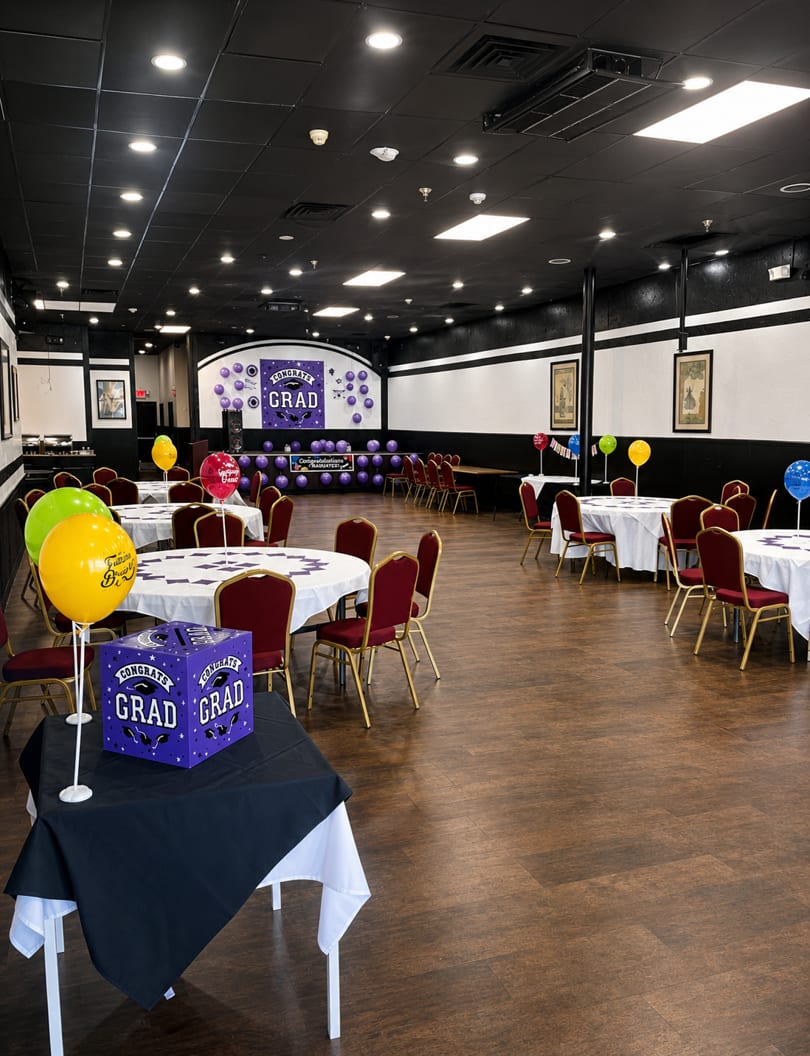 Spacious restaurant dining room set up for a graduation party with purple and yellow decorations.